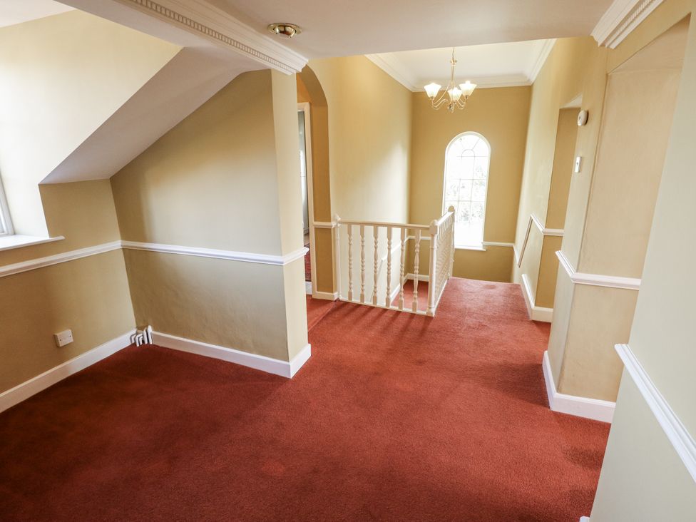 A hallway with a staircase and window at Holme Farm in Ruskington