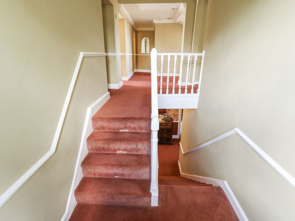 A hallway with stairs and handrail at Holme Farm in Ruskington