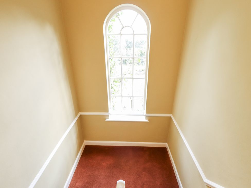 A staircase with a window and carpet at Holme Farm in Ruskington