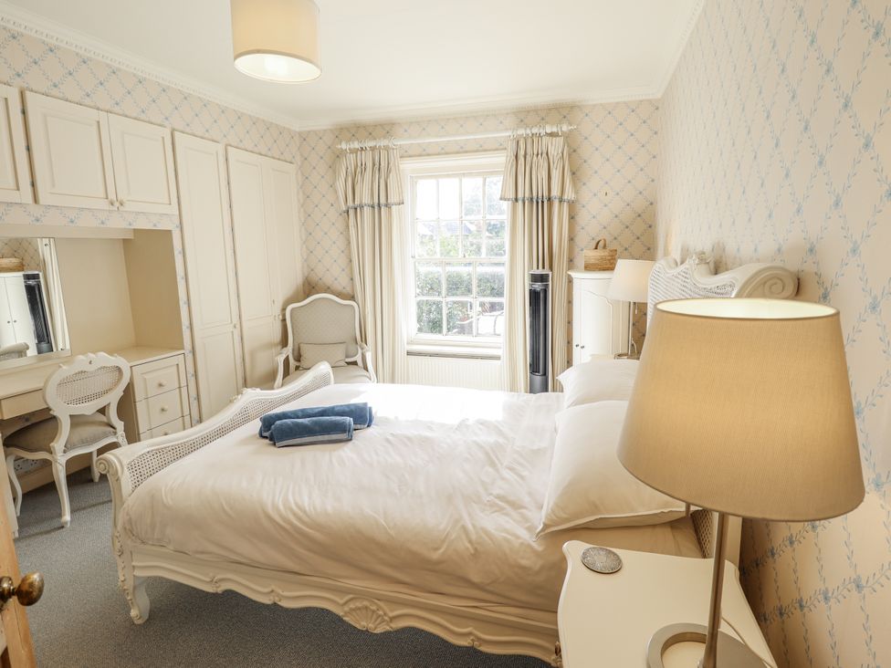A bedroom with a bed and dressing table at Holme Farm in Ruskington