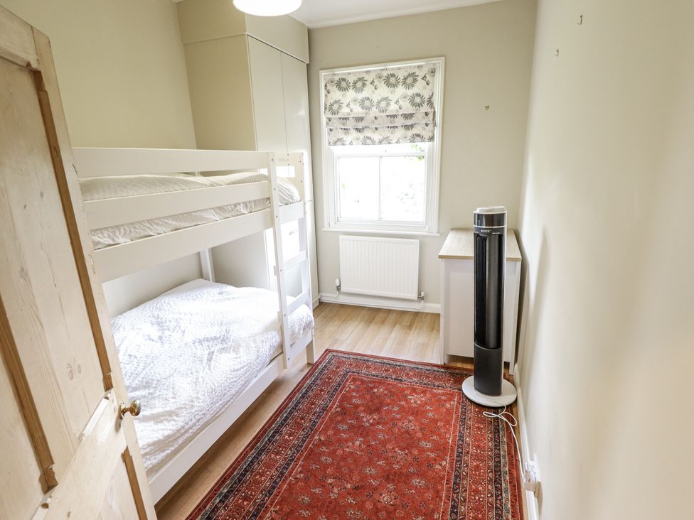 A bedroom with a bunk bed and a window at Holme Farm in Ruskington