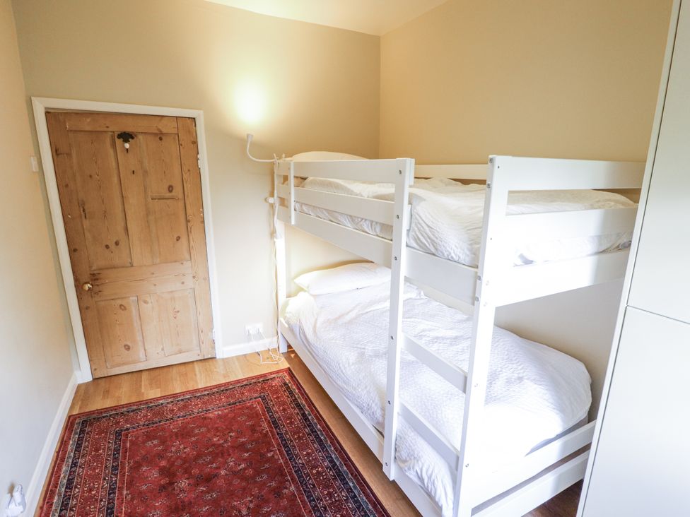 A bedroom with a bunk bed and a single bed at Holme Farm in Ruskington