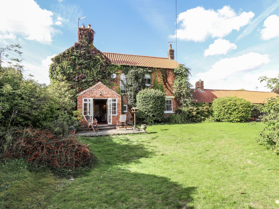 A house with a garden and patio at Holme Farm in Ruskington