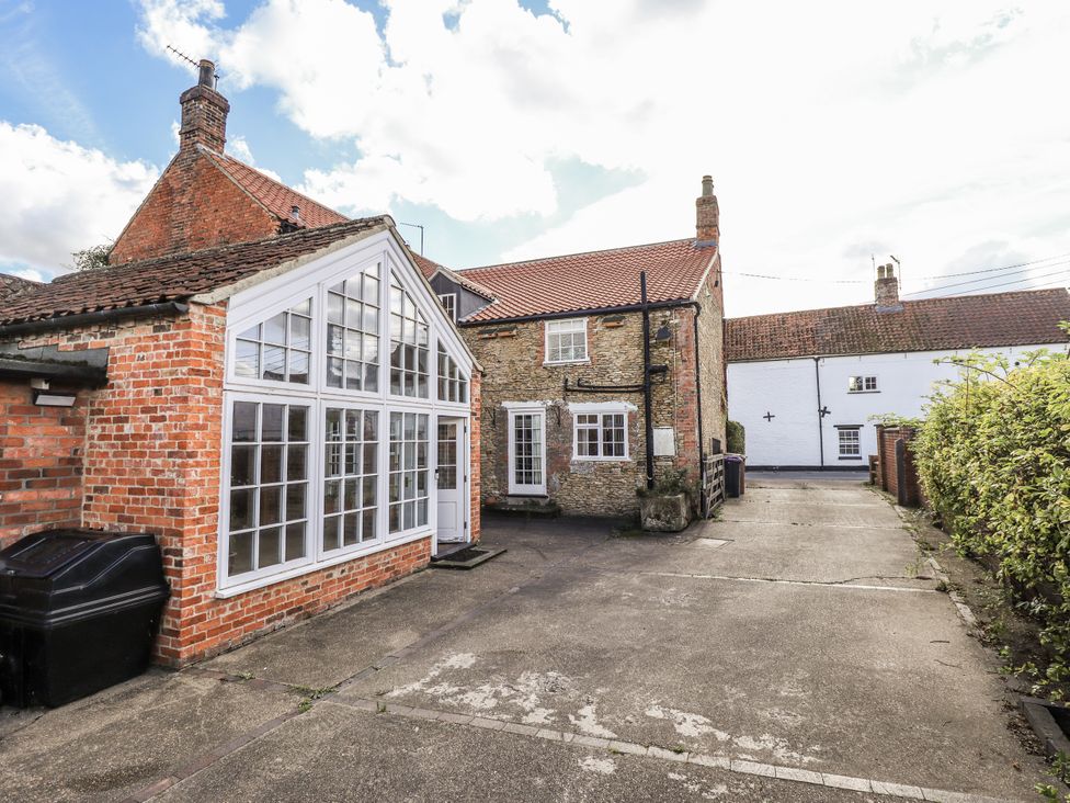 An outdoor view of a house with a driveway at Holme Farm in Ruskington