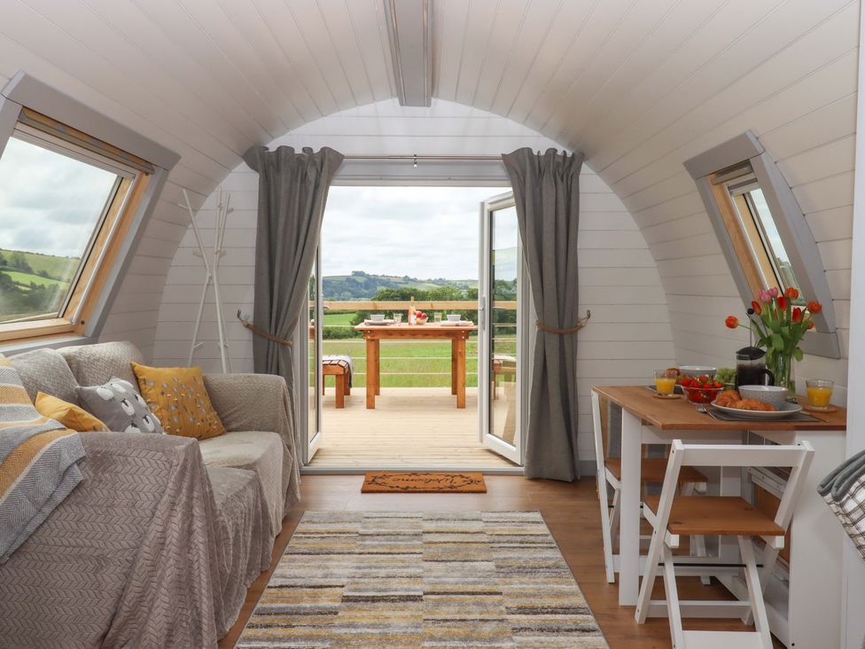 A living room with a sofa and table at Under Oak Pod in Totnes