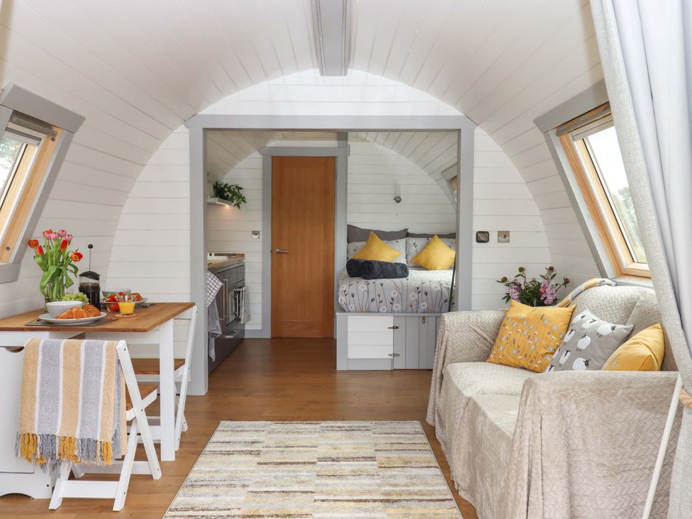 A living room with a table and couch at Under Oak Pod in Totnes