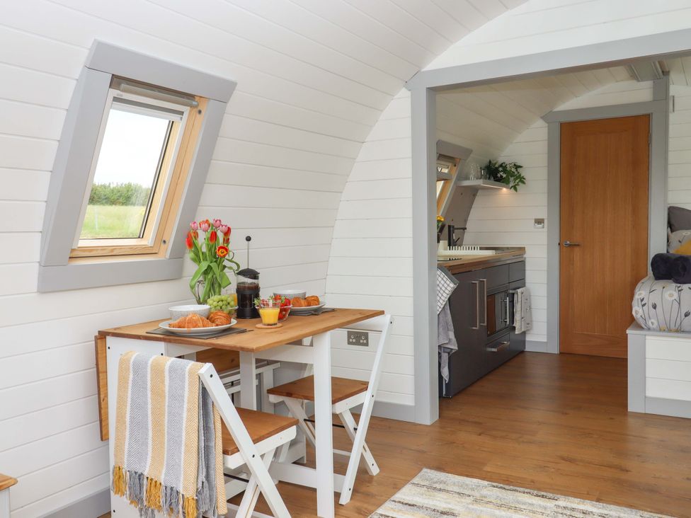 A kitchen with a dining table and chairs at Under Oak Pod in Totnes