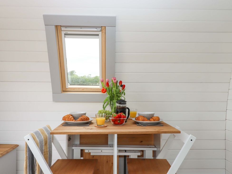 A kitchen table with food and drinks at Under Oak Pod in Totnes
