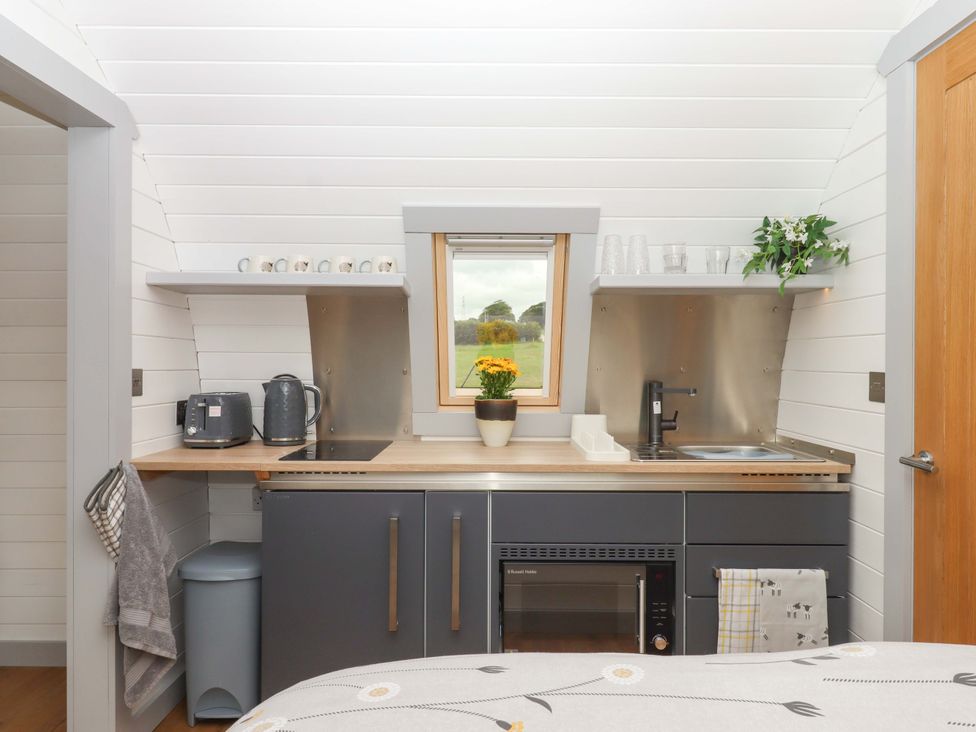 A kitchen area with sink and cupboard at Under Oak Pod Totnes
