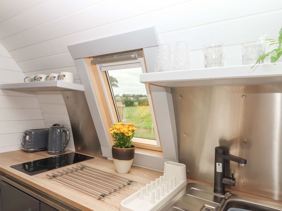 A kitchen with a sink and stove at Under Oak Pod in Totnes