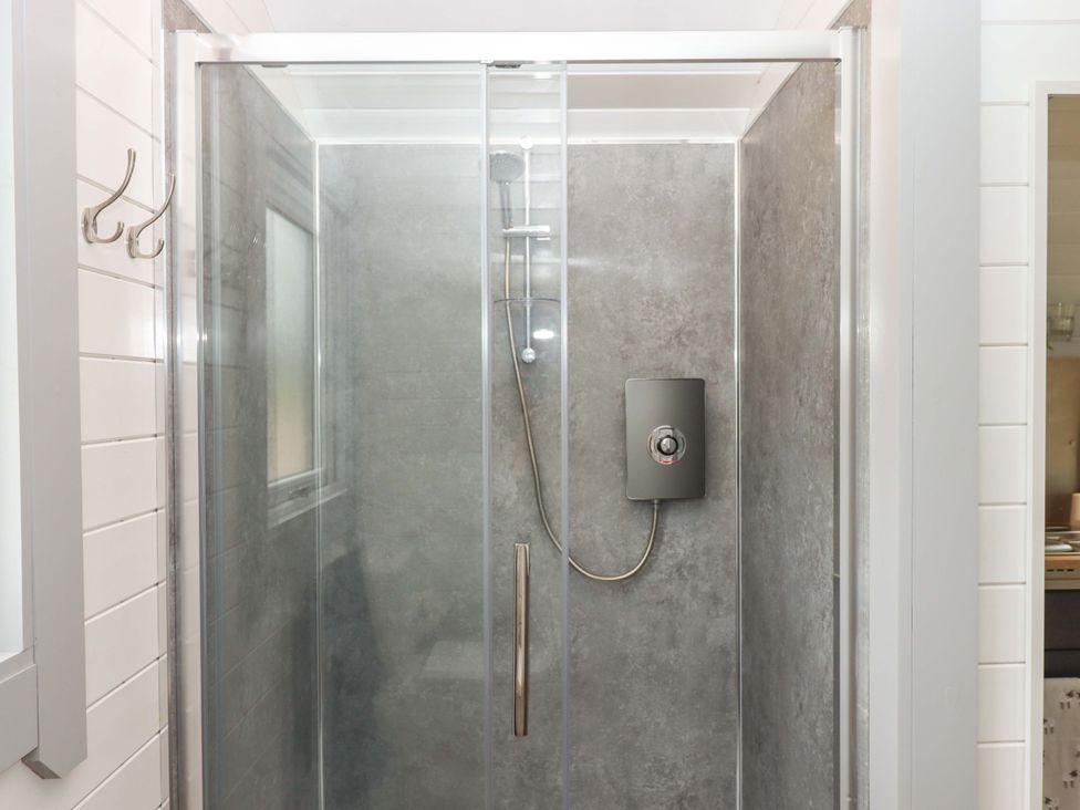 A shower enclosure with glass doors at Under Oak Pod in Totnes