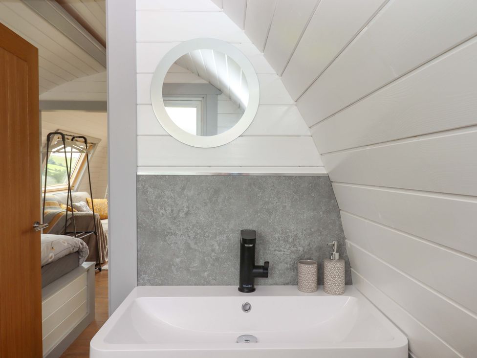 A bathroom with a sink and mirror at Under Oak Pod in Totnes
