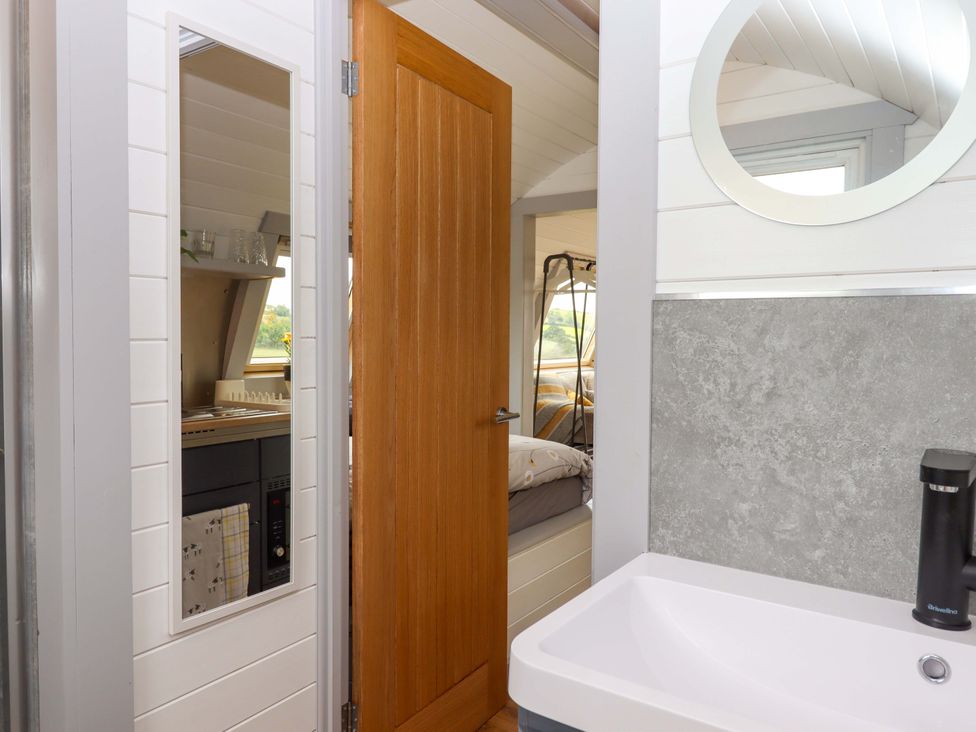 A bathroom with a sink and mirror at Under Oak Pod in Totnes