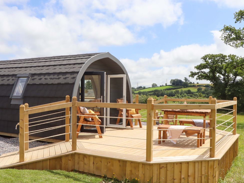 A cabin with a deck and outdoor seating at Under Oak Pod in Totnes
