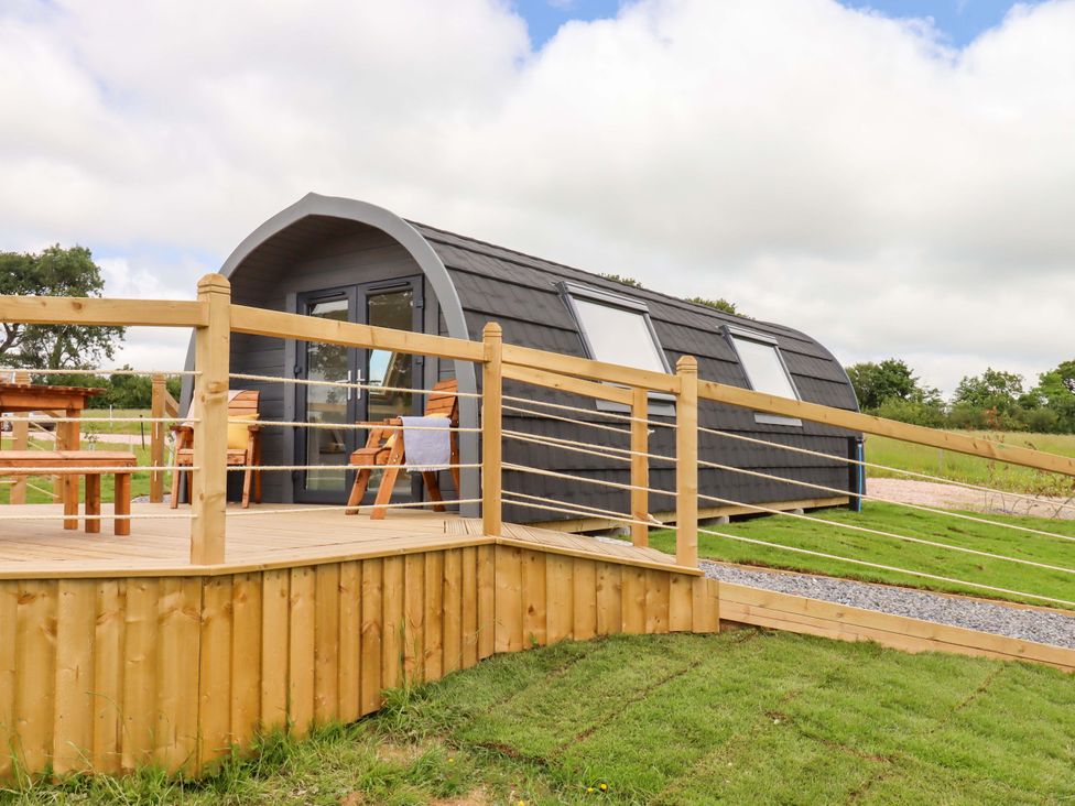 A pod with a deck and seating area at Under Oak Pod in Totnes