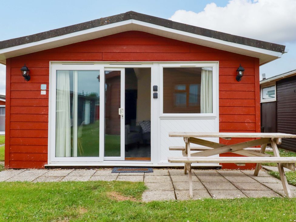 A cabin exterior with a picnic table at H2 Atlantic Bay Holiday Park in Padstow