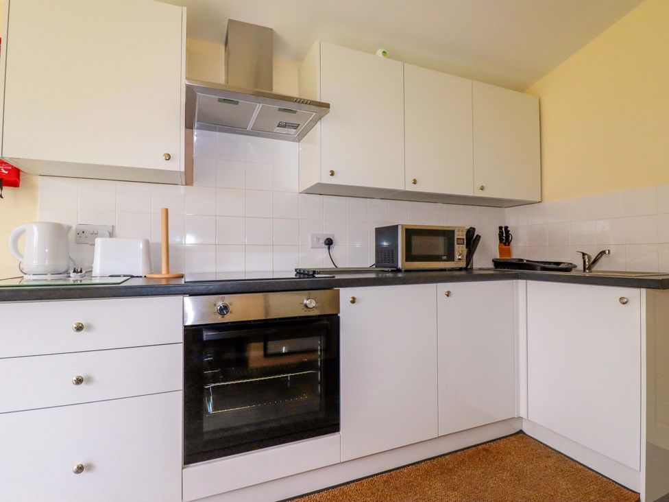 A kitchen with appliances and cabinets at H2 Atlantic Bay Holiday Park in Padstow