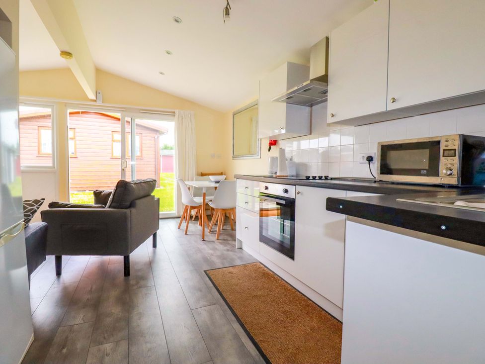 A kitchen with a dining area and sofa at H2 Atlantic Bay Holiday Park in Padstow