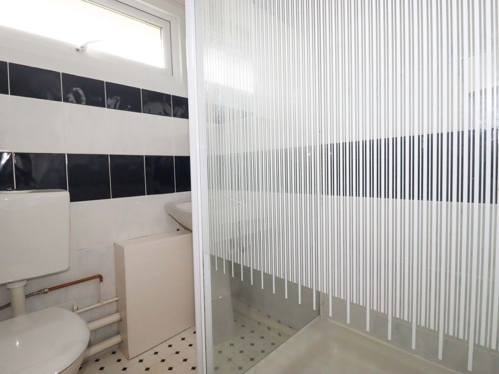 A bathroom with a toilet, sink, and shower at H2 Atlantic Bay Holiday Park, Padstow