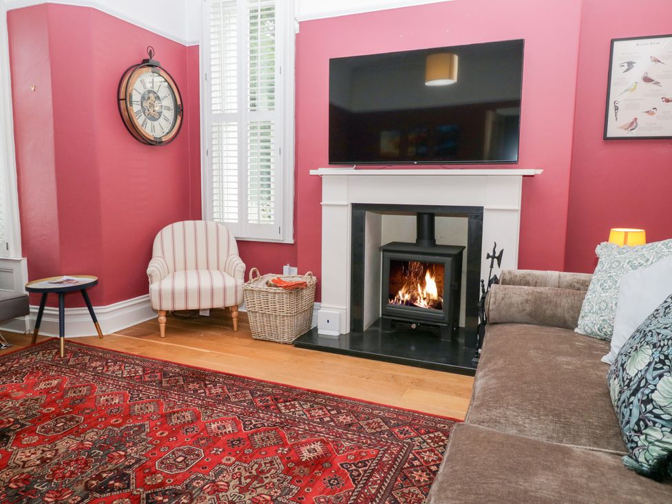 A living room with a fireplace and a TV at Sunnycroft in Keswick