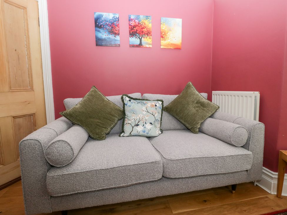 A living room with a sofa and wall art at Sunnycroft in Keswick