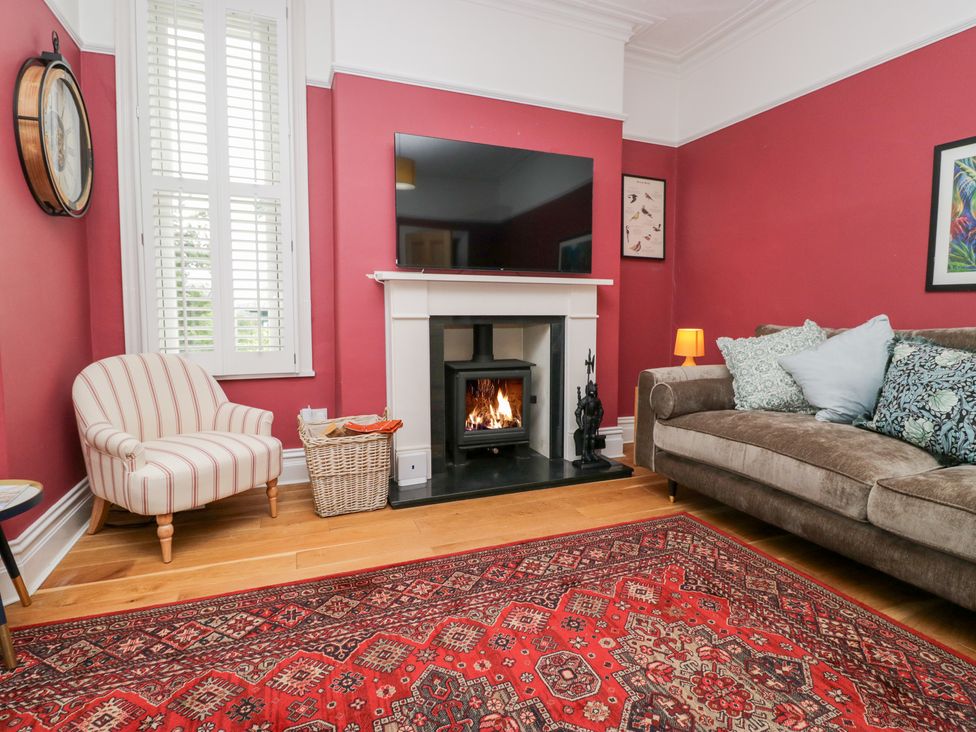 A living room with a fireplace and a sofa at Sunnycroft in Keswick