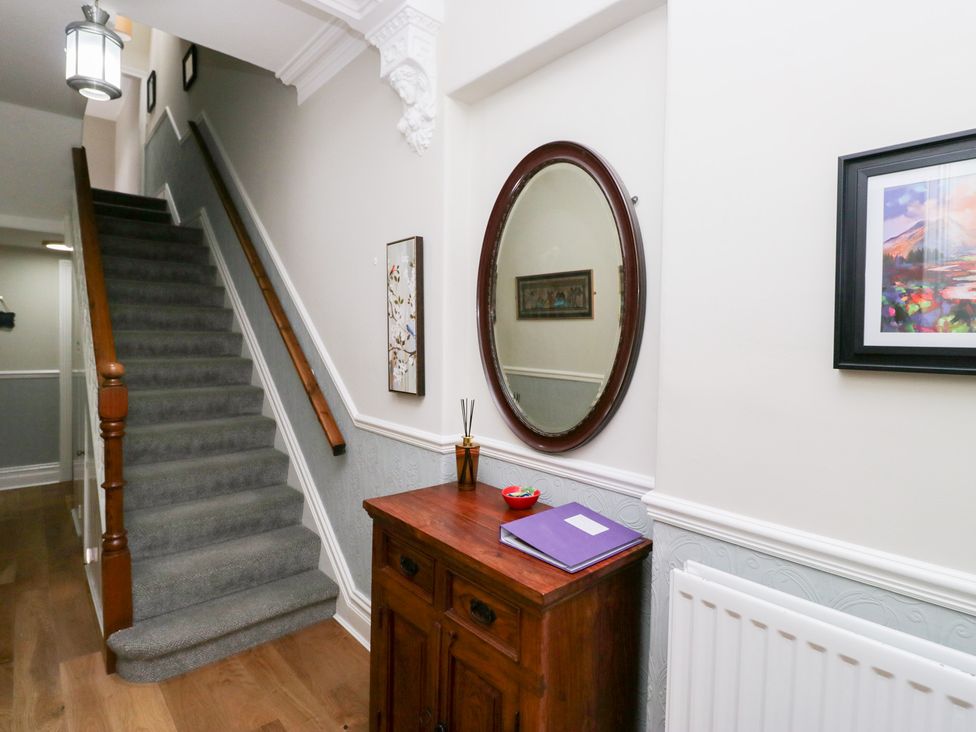 A hallway with stairs and a mirror at Sunnycroft in Keswick