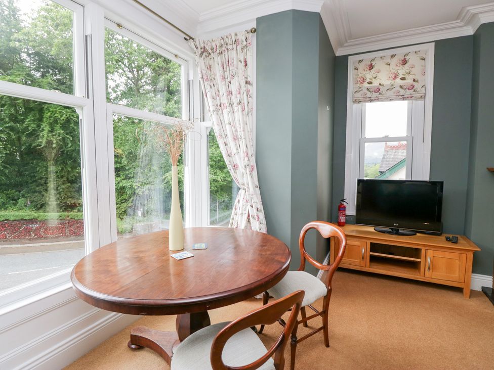 A living room with a table and a television at Sunnycroft in Keswick