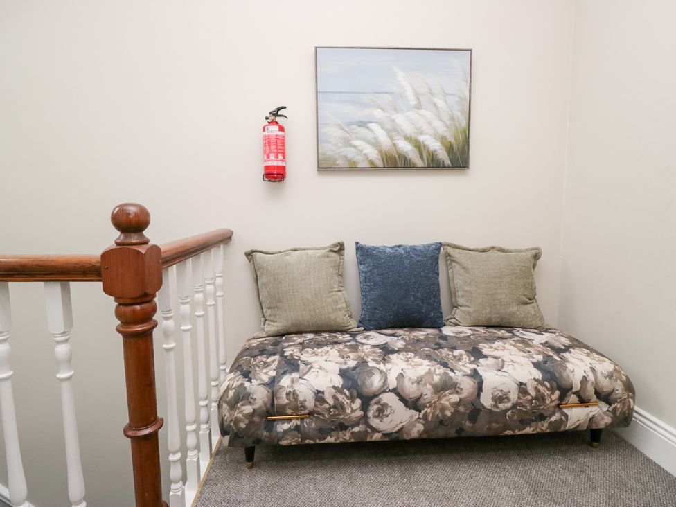 A couch with cushions and a painting in a hallway at Sunnycroft in Keswick