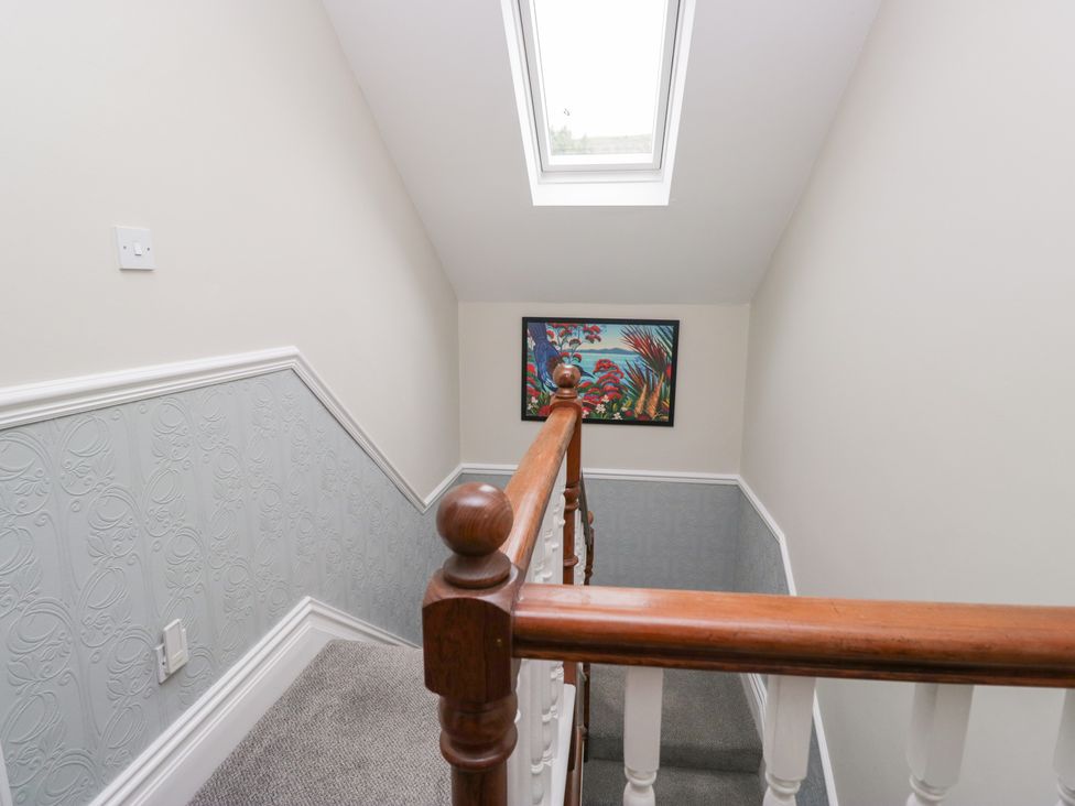 A staircase with a handrail and artwork at Sunnycroft in Keswick
