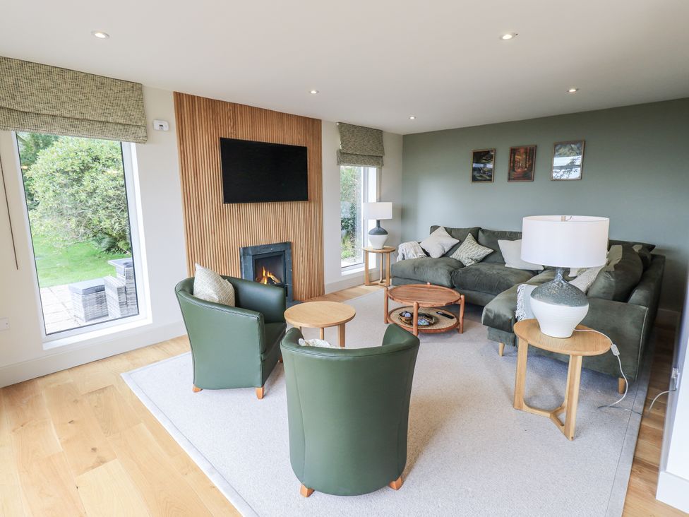 A living room with a sofa, armchairs, and a coffee table at Rowanhill in Kendal