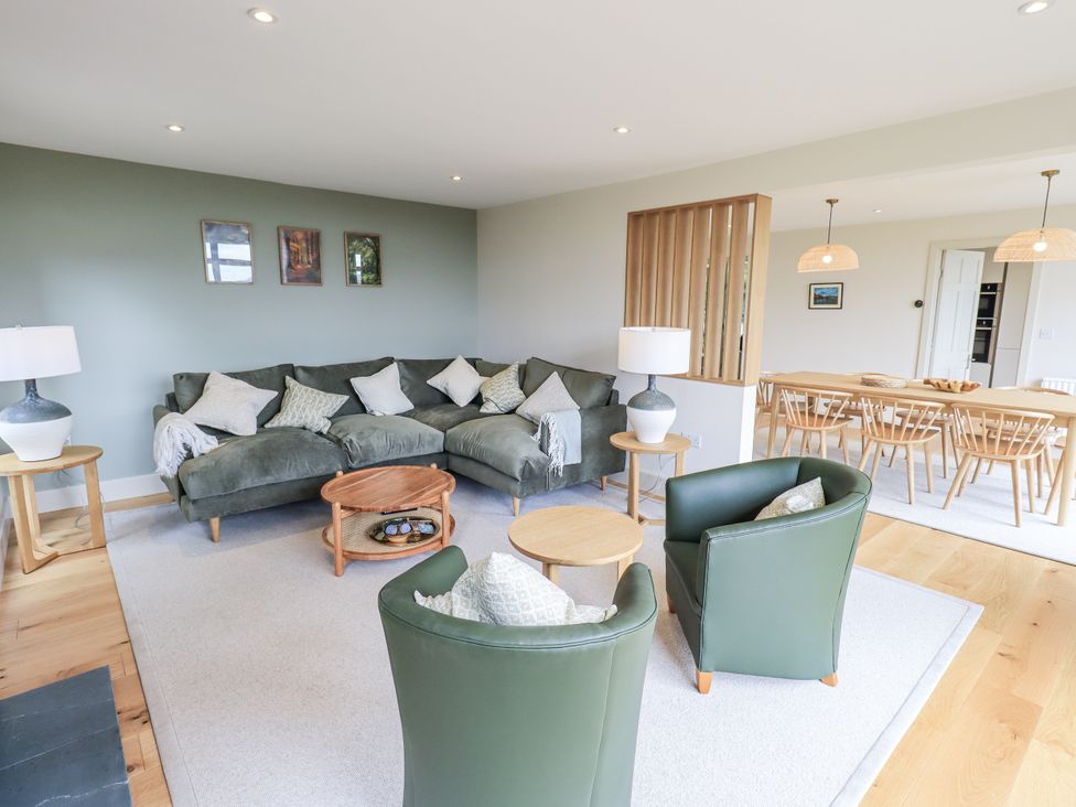 A living room with a sofa and dining area at Rowanhill in Kendal