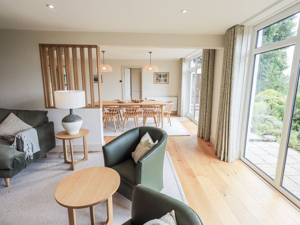 A living room with a sofa and dining area at Rowanhill in Kendal