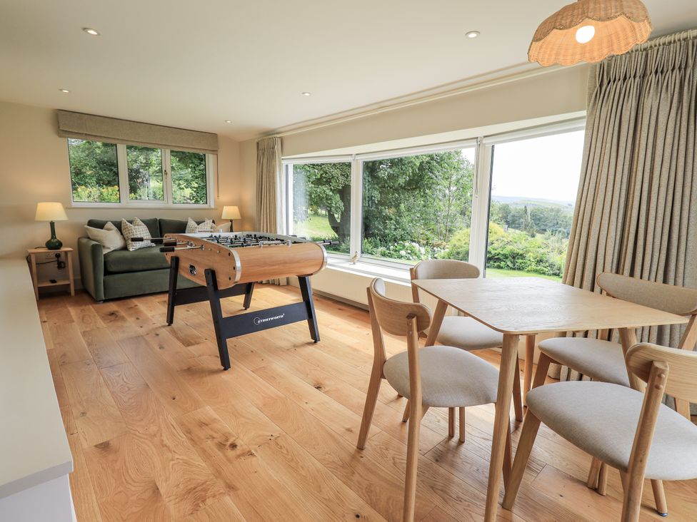 A living room with a foosball table and sofa at Rowanhill in Kendal