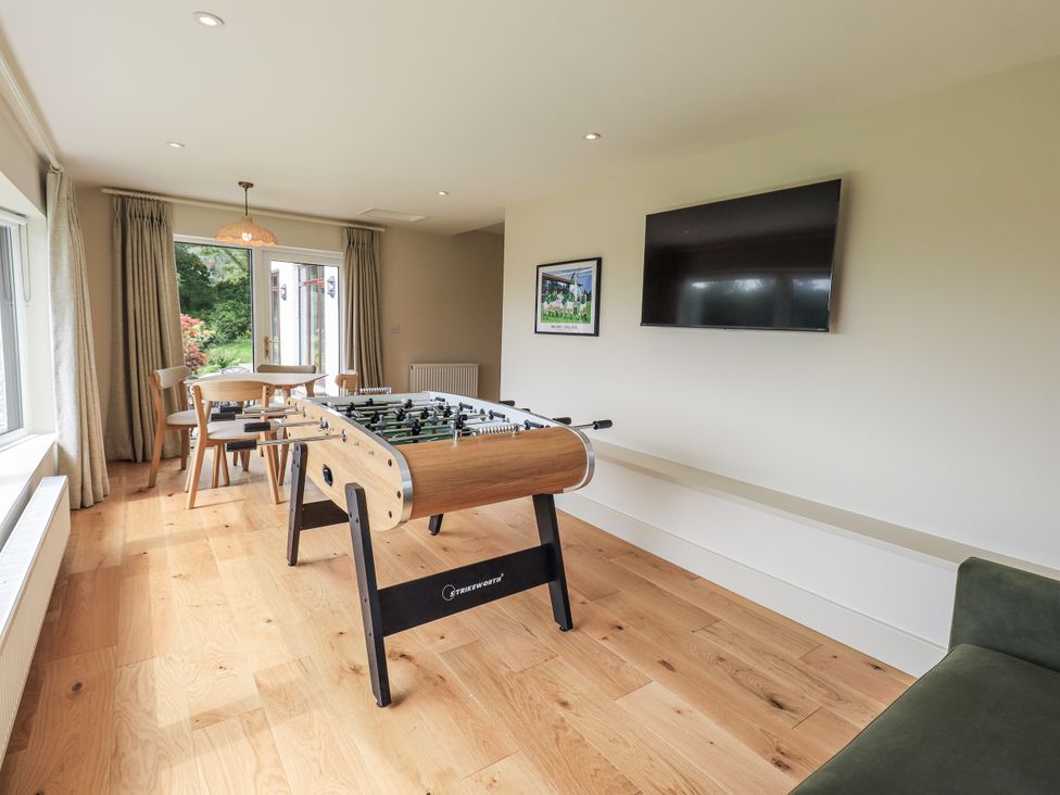 A game room with a foosball table and television at Rowanhill in Kendal