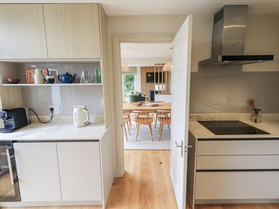 A kitchen with a view into a dining area at Rowanhill in Kendal