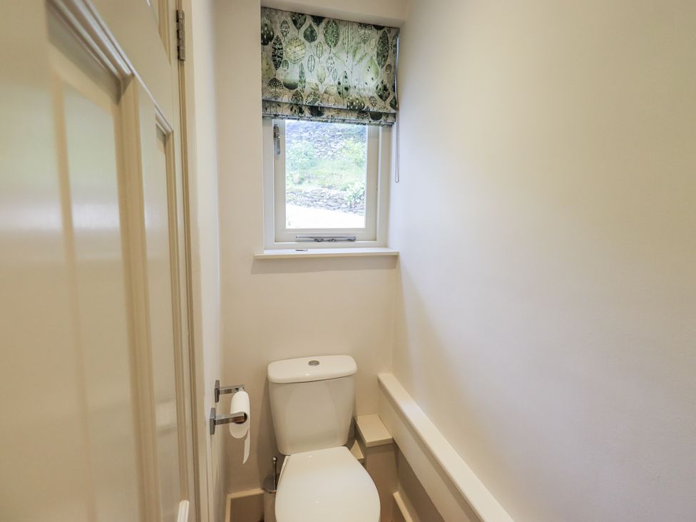 A bathroom with a toilet and a window at Rowanhill in Kendal