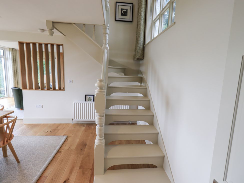 A staircase with a handrail in a hallway at Rowanhill in Kendal