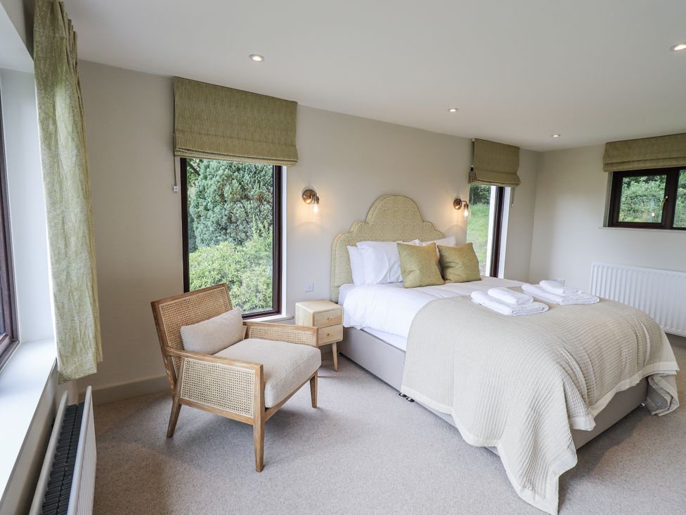 A bedroom with a bed and chair at Rowanhill in Kendal
