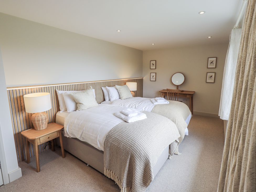 A bedroom with two beds and a desk at Rowanhill in Kendal
