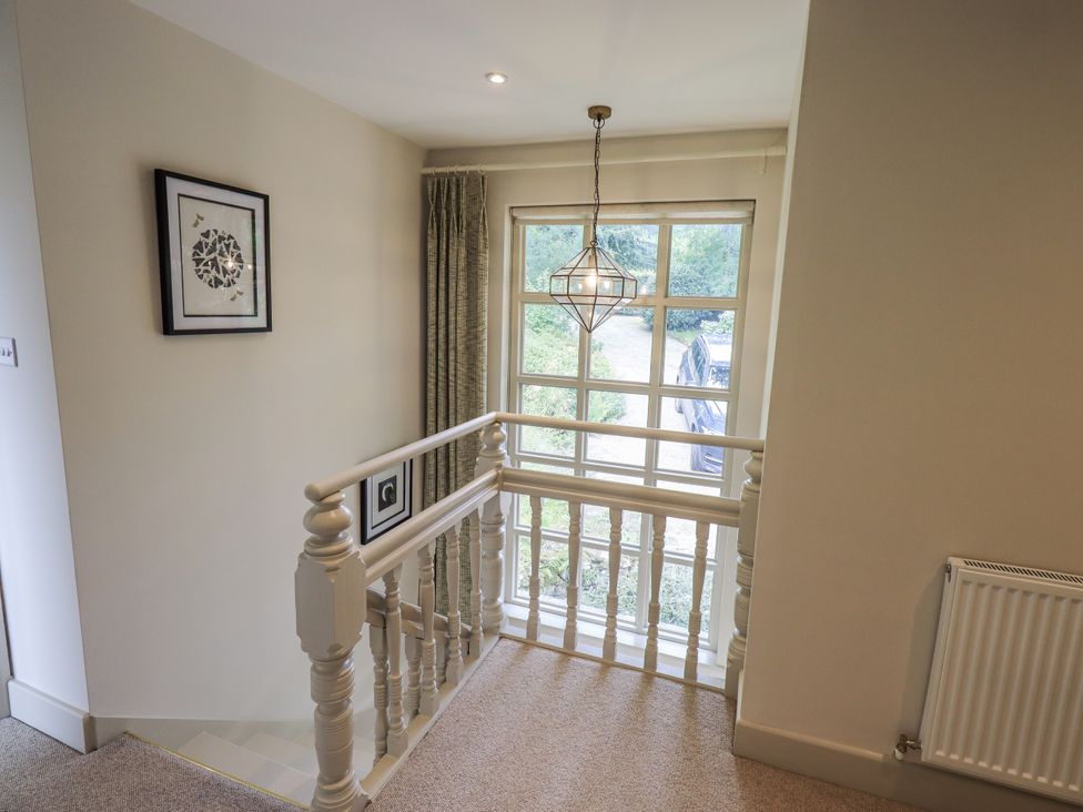 A staircase with a railing and window at Rowanhill in Kendal