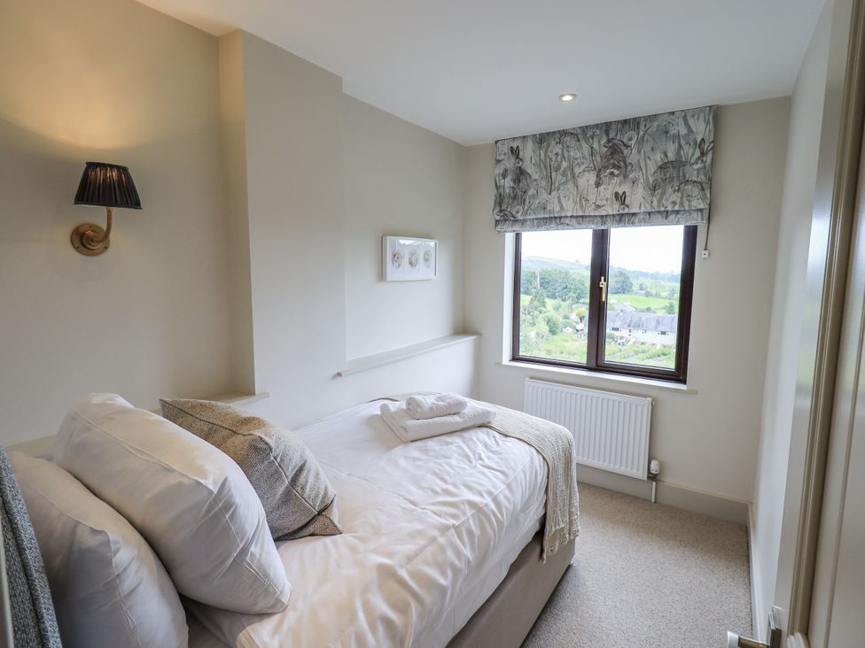 A bedroom with a bed and window at Rowanhill in Kendal
