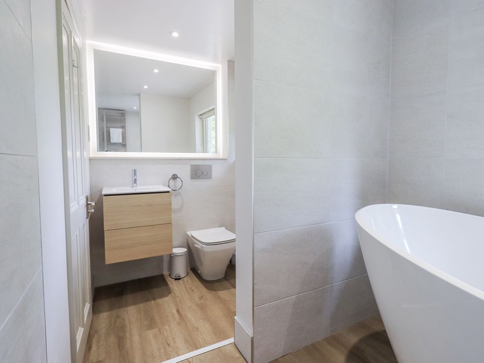 A bathroom with a bathtub and sink at Rowanhill in Kendal