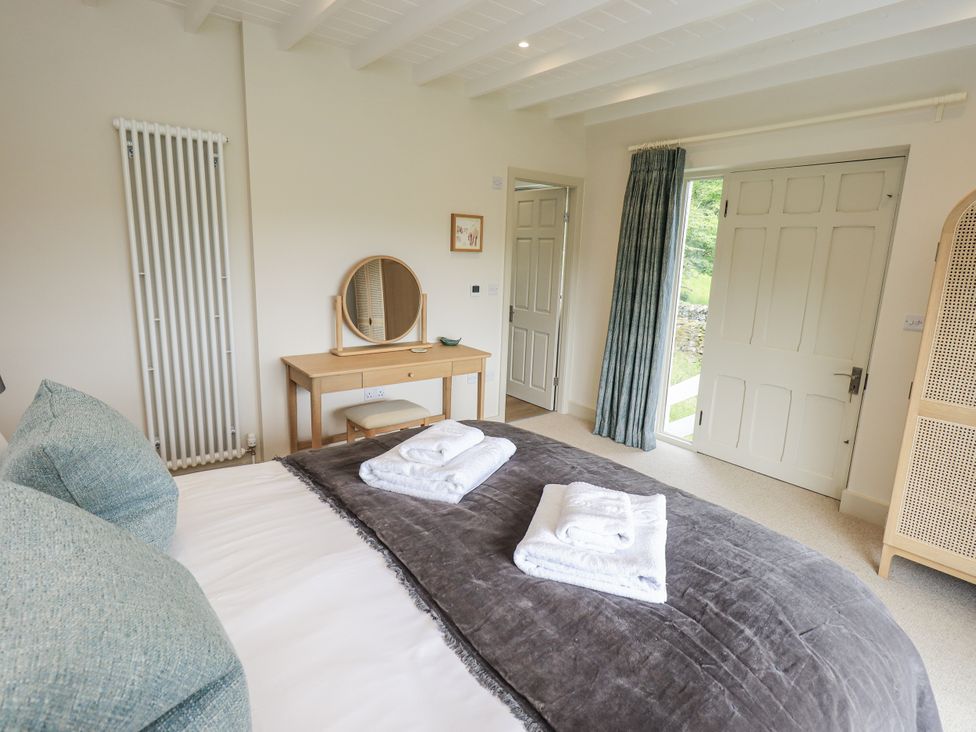 A bedroom with a bed and dresser at Rowanhill in Kendal