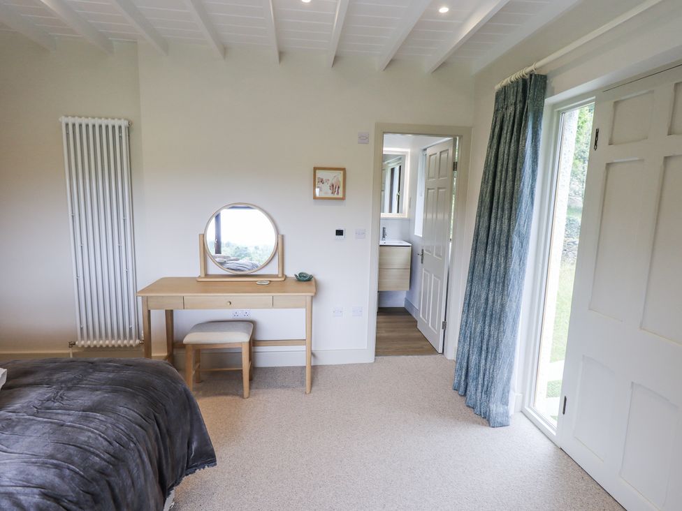 A bedroom with a bed, desk and chair at Rowanhill in Kendal