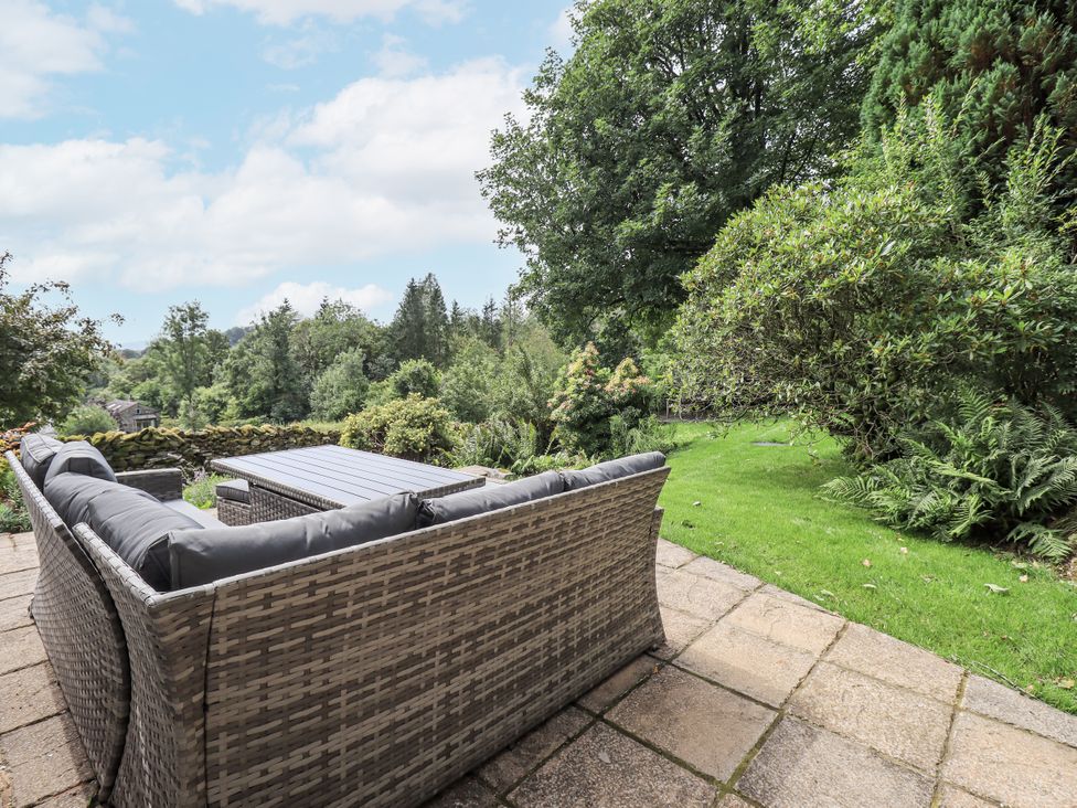 A garden with an outdoor sofa and a coffee table at Rowanhill in Kendal