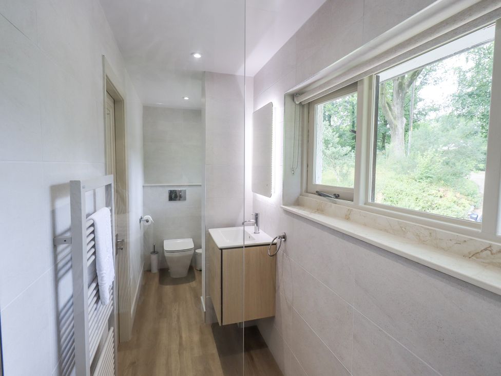 A bathroom with a sink, toilet, and window at Rowanhill in Crook near Staveley