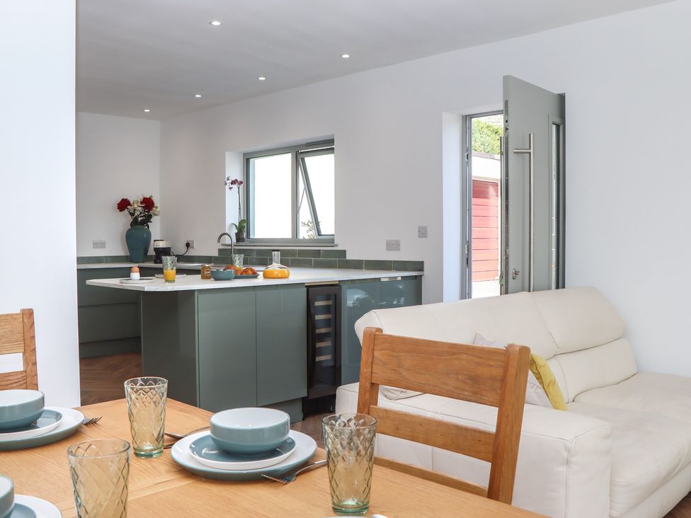 A kitchen with dining table and chairs at Seacroft in Torquay
