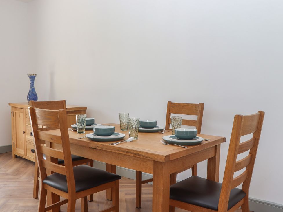 A dining room with a wooden table and chairs at Seacroft in Torquay
