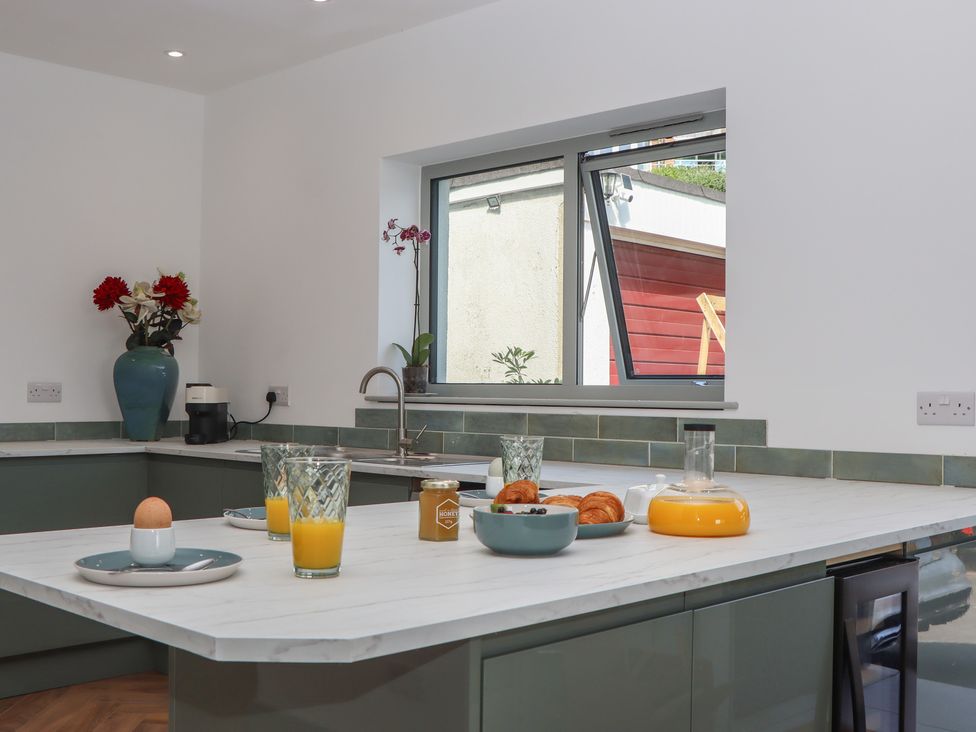 A kitchen with a large window, sink, and breakfast items at Seacroft in Torquay